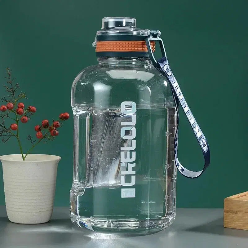 Look Loom 2 liter gym water bottle clear plastic with orange lid and carry strap on kitchen counter
