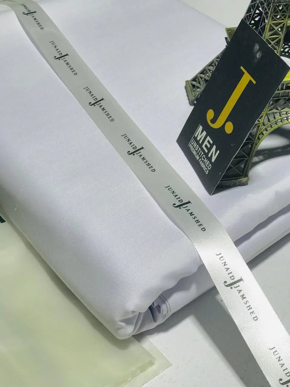 Look Loom white fabric roll for men's unstitched wash and wear suit neatly folded with brand J Men tag