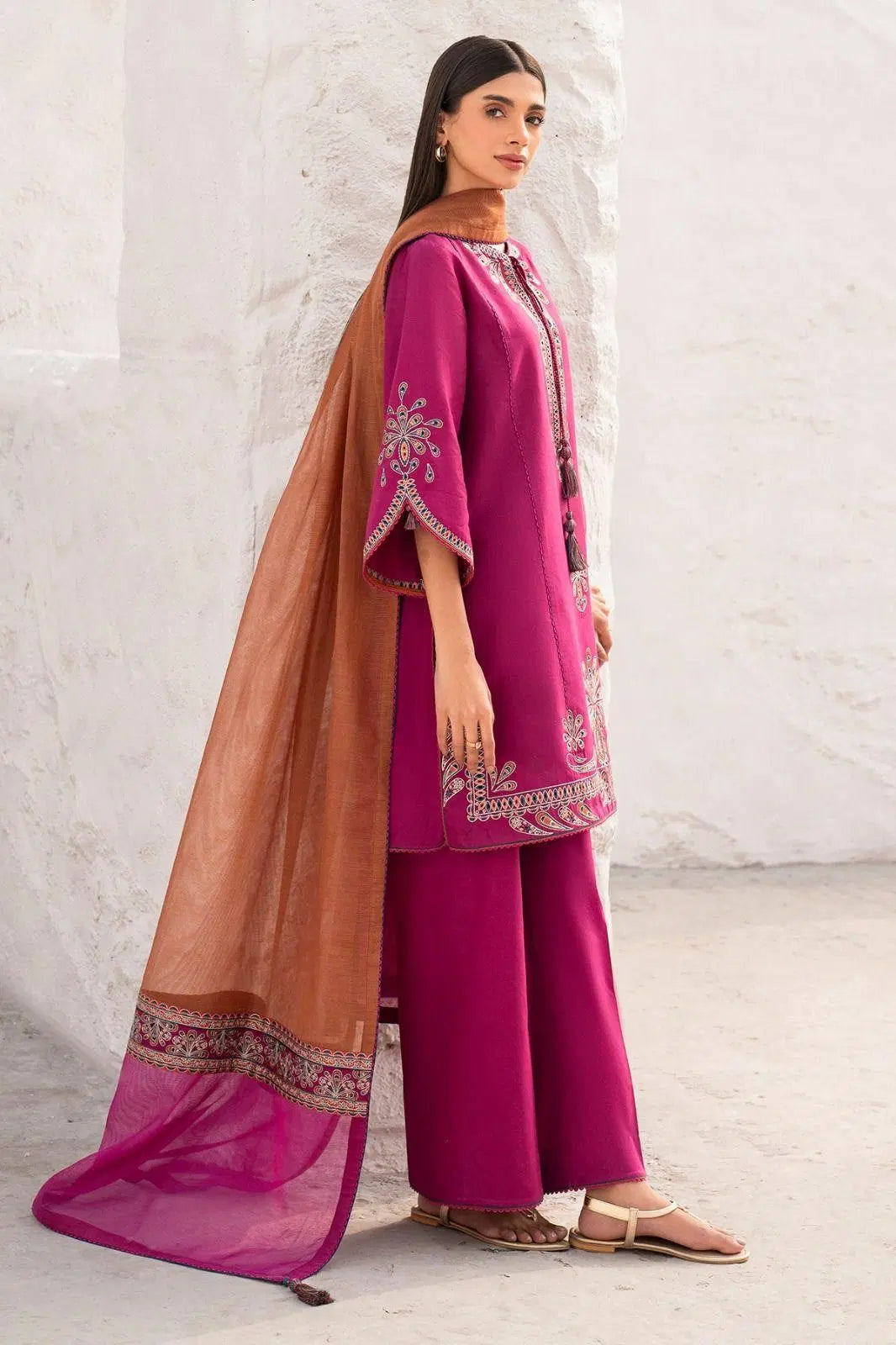 Look loom women wearing a 3 piece embroidered suit set in pink with detailed embroidery and brown dupatta